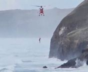 Dramatic footage shows the moment a dog walker was airlifted to safety - after falling into the sea.&#60;br/&#62;&#60;br/&#62;The man was walking along Cottys Point in Perranporth, Cornwall, when he was cut off by the tide on at around 4:30pm on Wednesday (March 27).&#60;br/&#62;&#60;br/&#62;Video taken by an onlooker shows the daring rescue mission in rough sea as an RNLI lifeboat first pulls him from the sea before he&#39;s wynched up to a helicopter to safety.&#60;br/&#62;&#60;br/&#62;Tragically, the charity was unable to save his dog, which had been washed away.&#60;br/&#62;&#60;br/&#62;Onlooker Steve Finnay, 49, who filmed the rescue, said: &#92;